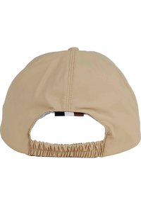 Gorra beige con una corona redondeada y parte trasera fruncida. Presenta un detalle a rayas en rojo, blanco y azul en la abertura. Textura suave.
