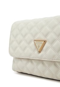 Borsa a tracolla in similpelle bianca trapuntata con logo triangolare dorato, caratterizzata da cuciture diagonali e chiusura a pattina.