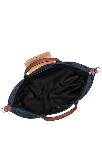 Blue nylon tote bag with brown leather handles. Interior is black fabric with a zippered pocket. Features a flap closure with snap button.