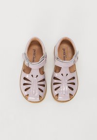 Lila lackläder sandaler med utskärningar, spänne och en brun läderfotbädd. Slät yta med platt sula.