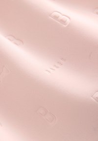 Tessuto rosa morbido con una texture liscia, caratterizzato da un motivo in rilievo della lettera "B" e della parola "BAKED" in un design sottile.