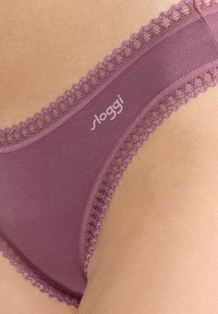 Lila bomullsunderkläder med spetsdetaljer, med en logotyp på midjebandet. Mjuk textur och en slät yta.