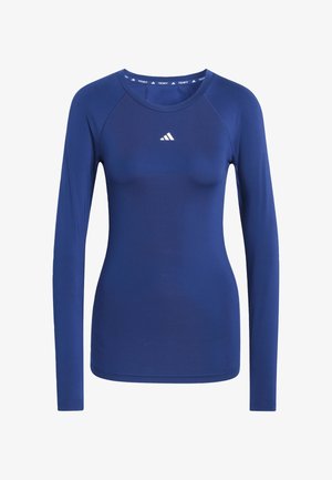 Long-sleeve athletic shirt in dark blue fabric. Features a round neckline, flat seams, and a small white logo on the chest.