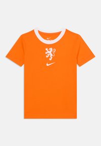 Orange bomullströja med vitt rundhals. Har en vit lejongrafik och Nike-logotyp centrerad på bröstet. Korta ärmar.