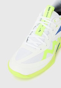 Λευκό αθλητικό παπούτσι με νεον κιτρινο λακτίσματα, λευκά κορδόνια, μπλε λογότυπο στο πλάι και κείμενο "Momentum Pro" σε νεον κ ίτρινη ετικέτα στην γλώσσα.