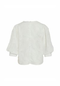 Blouse blanche avec un motif texturé, dotée de manches courtes et bouffantes, et d'une fermeture éclair au dos. Tissu uni, finition douce.