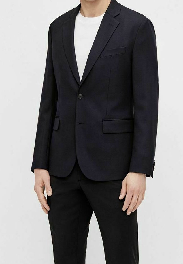 Granatowa marynarka z klapą w kształcie notch, z zapięciem na jeden guzik i dwoma przednimi kieszeniami. Gładki materiał z dopasowanym fasonem, noszona na białej koszuli.