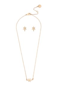Ensemble de bijoux en ton or comprenant un collier avec pendentif en forme d'étoile et des boucles d'oreilles assorties en étoile, ornés de petits strass clairs.