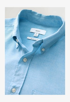 Camicia button-up azzurro chiaro con vestibilità regolare, realizzata in un tessuto con una sottile texture. Presenta un colletto classico e bottoni bianchi.