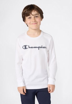 Langärmliges weißes T-Shirt mit Rundhalsausschnitt, das ein großes schwarzes "Champion"-Logo auf der Brust und gerippte Bündchen aufweist.