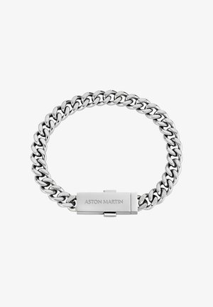 Sudraba ķēdes aproce ar lieliem savstarpēji savienotiem posmiem. Aizdares slēdzene ir gravēta ar uzrakstu "ASTON MARTIN." Gluds, pulēts metāla virsmas apdare.