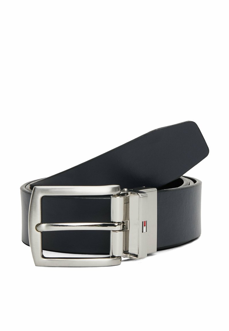 Zwijany czarny skórzany pasek z prostokątną srebrną metalową klamrą i małym detalem w postaci czerwono-biało-niebieskiej flagi na zapięciu.
