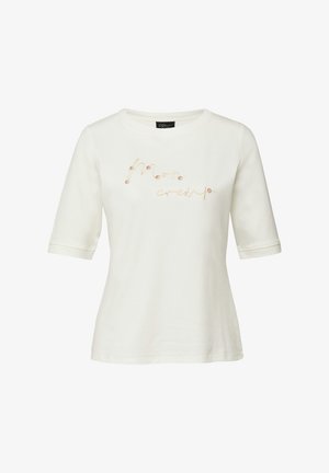 Biała koszulka z krótkim rękawem z haftowanym napisem "moon crew" w stylu kursywy z drobnymi kwiatowymi detalami na przodzie.