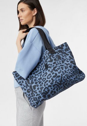 Tote-Bag mit blauem Leopardenmuster und schwarzen Griffen, aus strapazierfähigem Stoff gefertigt, mit geräumigem Design und glatter Textur.