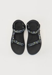 Sorte sandaler med fargerike mønstrede stropper i en blanding av grønn og blå akenter. Teksturert fotseng og robuste justerbare lukkinger.