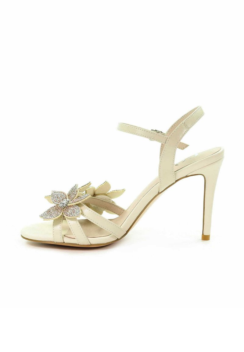 Beżowe sandały na wysokim obcasie z kwiatowym wzorem i rhinestones, wieloma detalami pasków oraz smukłym paskiem na kostkę. Gładka tekstura.