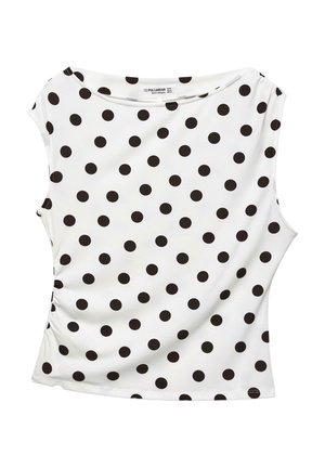 Top alb fără mâneci, cu buline negre mari dispuse uniform și o cusătură laterală ușor adunată.