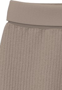 Beige geripptes Strickgewebe mit einer flauschigen Textur und einem breiten, umgeschlagenen Rippenbund.