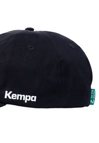 Sort kasket lavet af stof med en flad skygge. Har hvidt "Kempa" logo og et grønt "for the planet" tag på siden.