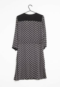 Musta mekko pitkillä hihoilla, jossa on kuvioitu vartalo valkoisilla, vaaleanpunaisilla ja sinisillä muodoilla. Sileä kangas, jossa on kontrastoiva kiinteä musta pääntie.