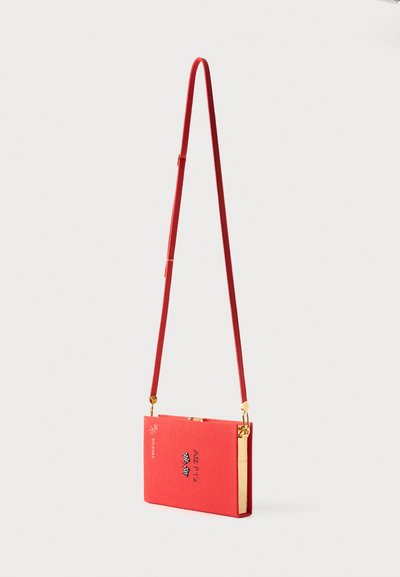 Κόκκινη ορθογώνια τσάντα crossbody με χρυσές λεπτομέρειες, ρυθμιζόμενο λουρί και το κείμενο "Ale Pz's" μαζί με δύο καρό σημαίες στο μπροστινό μέρος.