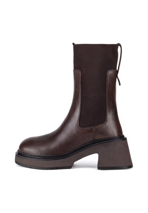Brauner Leder-Stiefel mit elastischen Seitenteilen, quadratischer Spitze und klobigem Absatz. Strukturierter Stoff oberhalb des Knöchels sorgt für Kontrast.