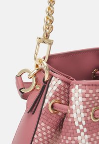 Sac seau en cuir rose avec un motif tissé, matériel en or et une chaîne épaisse. Présente des accents en boucle et des détails de couleur contrastante.