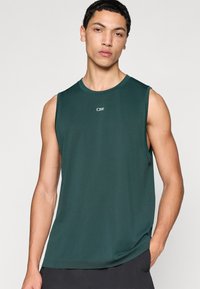 Σκούρο πράσινο αθλητικό τοπ χωρίς μανίκια με στρογγυλή λαιμόκοψη και μικρό λογότυπο στο στήθος· λείο, ελαφρύ ύφασμα με άνετη εφαρμογή.