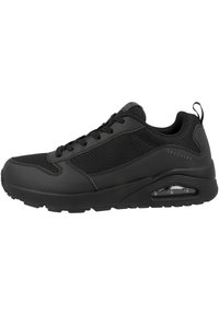 Sneakers neri con tomaia in sintetico testurizzato e pannelli in rete. Presentano una suola spessa e un'ammortizzazione ad aria visibile nel tallone.