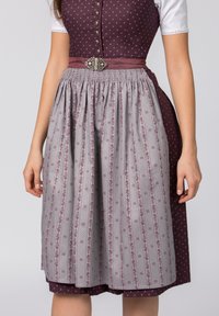 Traditional dress with a dark purple bodice featuring white polka dots. Gray skirt with floral and striped patterns, gathered waist, decorative belt.