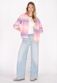 Pastellgradient cardigan i rosa och lila, lätt stickad kvalitet, öppen framsida, kombinerad med hög midja, vida ljusa denimjeans.