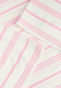 Λευκό ύφασμα με απαλές ροζ κάθετες και οριζόντιες ρίγες, εμφανίζοντας διπλωμένες άκρες και ορατές ραφές.