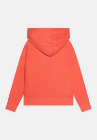 Sudadera con capucha de color coral, hecha de una tela suave, con un bolsillo tipo canguro, puños y dobladillo acanalados. Presenta un corte holgado y una capucha sin costuras.