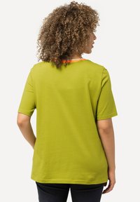 Zelené tričko s krátkým rukávem a kulatým výstřihem s oranžovým akcentem. Hladká tkanina a volný střih. Viděno zezadu.