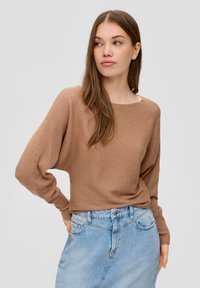 Brauner gerippter Strickpullover mit lockerer Passform und weitem Ausschnitt, getragen über einem hochtaillierten, hellblauen Jeansrock. Weiche Textur und entspannter Stil.
