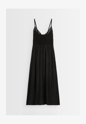 Vestito midi senza maniche di colore nero con corpetto a uncinetto e sottili spalline, gonna fluttuante, appeso su uno sfondo bianco.