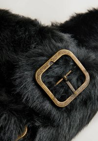 Sort faux pels med en blød tekstur og en firkantet bronze spænde detalje, der har en centreret nål til fastgørelse.