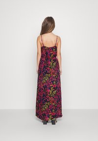 Maxiklänning i mörk tyg med livfull blommönster i rosa, gult och grönt. Tunna spaghettistilar, avslappnad passform och ankellängd.