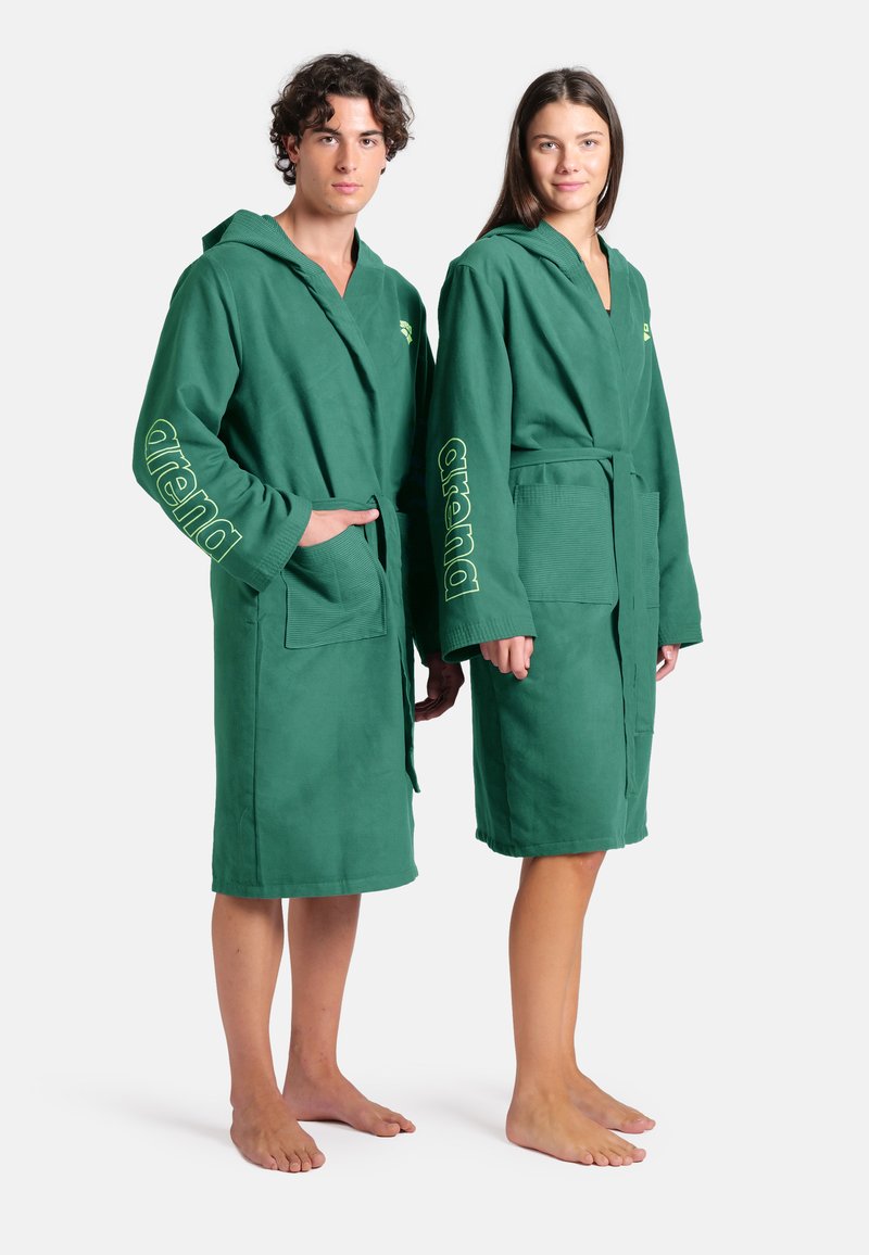 Groene badjassen met capuchon en een textuurafwerking, voorzien van zakken aan de voorkant en 'arena' branding in het geel op de mouwen. Standaard pasvorm.