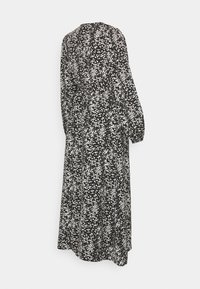 Vestido longo preto com padrão floral branco, apresentando mangas bufantes longas e uma cintura franzida. O tecido é leve com uma silhueta fluida.