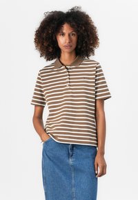 Brun og hvit stripet polo-skjorte med krage, med en liten logo på brystet, kombinert med et denimskjørt. Glatt tekstur.