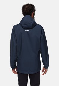 Navy waterproof jacket with a hood, featuring a smooth texture, elastic cuffs, adjustable hem, and a logo on the back.