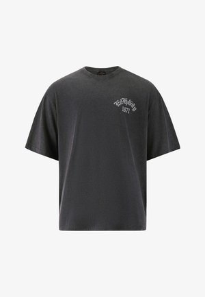 Mustat ylisuuret t-paidat, jotka on valmistettu pehmeästä puuvillasta. Paidassa on pieni valkoinen graafinen printti, jossa lukee '1971' vasemmassa rintakappaleessa, ja pyöreä pääntie.