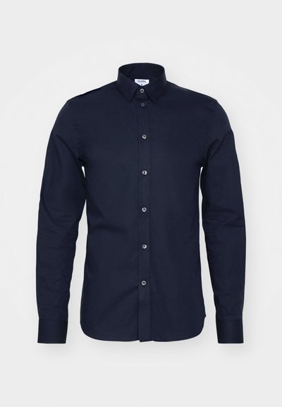 Tumesinine pikad varrukad särgid, mis on valmistatud puuvillast, nupuga krae ja eesnupu detailidega. Omab siledat tekstuuri ja struktureeritud sobivust.