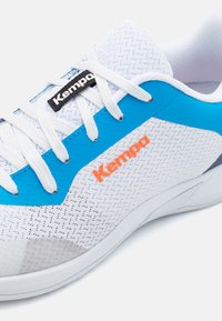 Witte sportieve schoen met blauwe accenten, bovenwerk van mesh en oranje logo. Voorzien van witte veters en een gestructureerde zool voor grip.