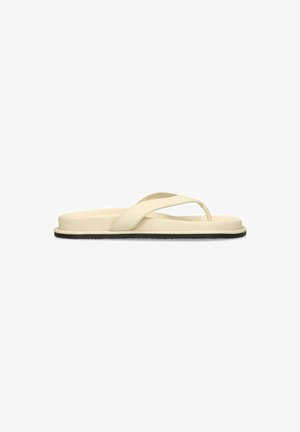 Beige flip-flop sandal with padded sole and wide cross strap, featuring a black flat outsole, shown from the side on a white background.