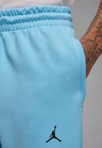 Jasnoniebieskie szorty dresowe wykonane z miękkiej tkaniny z elastycznym pasem. Posiadają czarne logo Air Jordan na lewej nogawce.