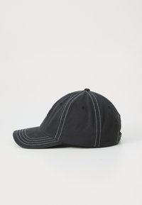 Svart baseballcap laget av bomull med hvit søm, buet skjerm, teksturert stoff og en glatt overflate på utsiden.
