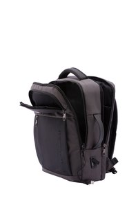 Zaino in tessuto grigio con una tasca frontale con zip, pannello laterale curvo e una dettagliata porta USB. Doppi manici e spallacci regolabili imbottiti.