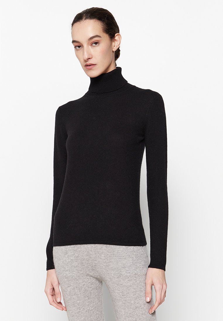 Zwarte coltrui gemaakt van een zachte gebreide stof. Voorzien van lange mouwen en een aansluitende silhouet. Eenvoudig ontwerp, geen zichtbare patronen of hardware.